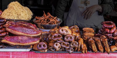 PIGGING OUT IN BEIJING NIGHT MARKET by John Rutherford